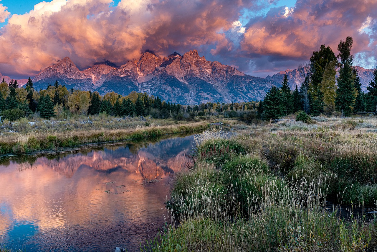 Paysage de montagne se reflétant dans une rivière calme, illustrant l'effet miroir, les résonances relationnelles et la connaissance de soi.