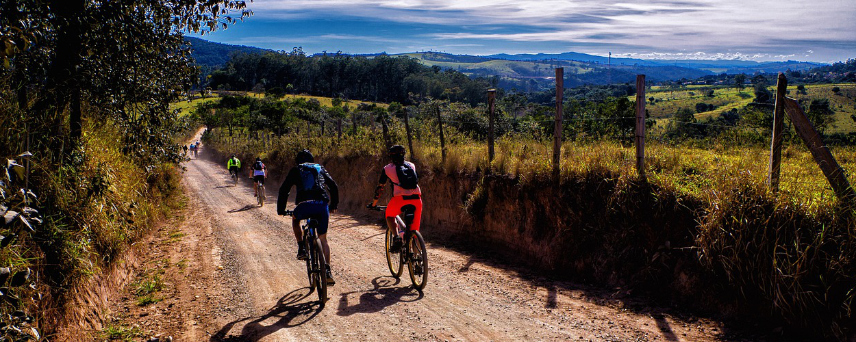 Cyclistes avançant sur un sentier de campagne, illustration du parcours de découverte, de régulation émotionnelle et de développement des ressources personnelles.