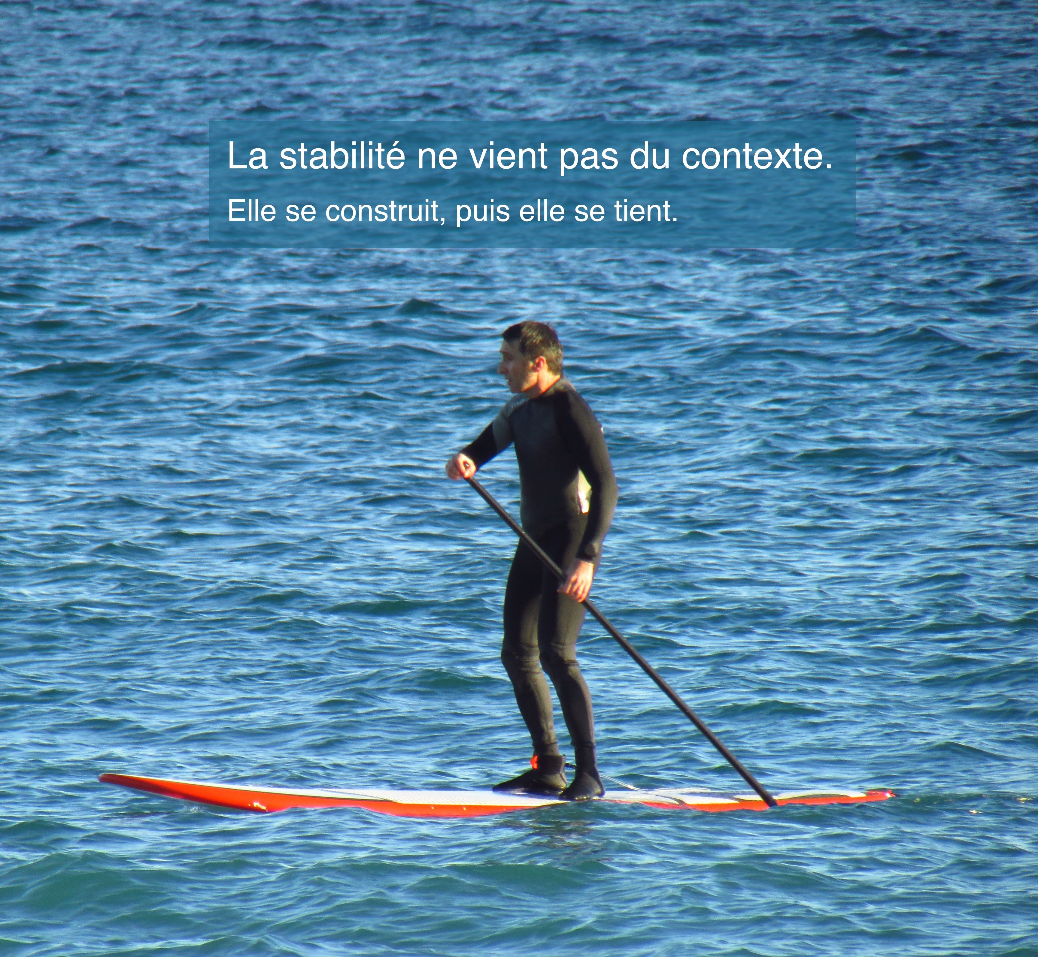 Personne pratiquant le paddle sur une mer agitée, illustrant la capacité à maintenir stabilité, engagement et disponibilité mentale malgré les variations de l'environnement.